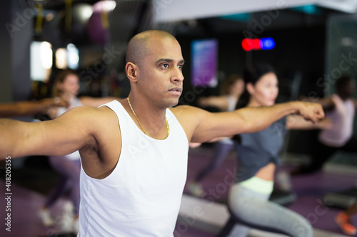 Man with others doing step aerobics in a fitness club © JackF