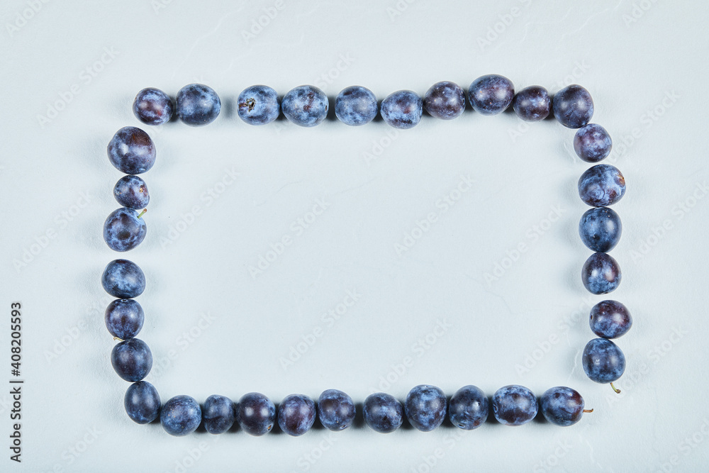Group of fresh plums on a blue background