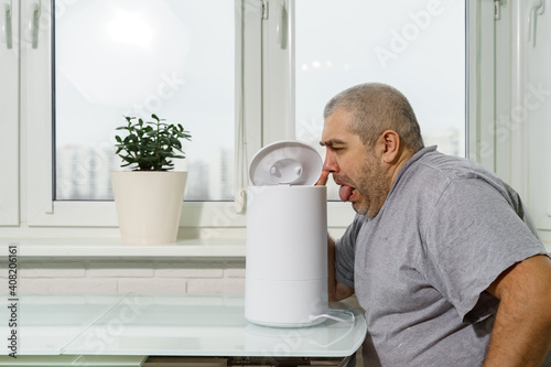 Tablou pe pânză the big gray-haired man doesn't like the smell from the humidifier
