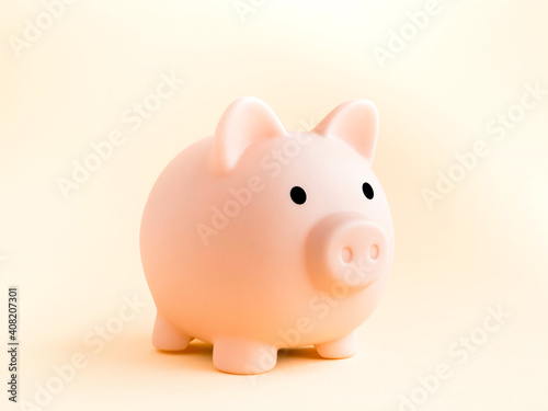 Cute piggy bank, pink color isolated on soft beige background. Saving money, Investment and finance concept. © tete_escape