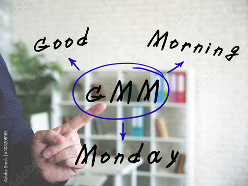  GMM Good Morning Monday inscription. Male hand pointing on background. photo