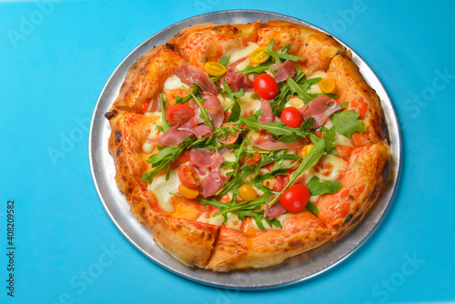 A Pepperoni pizza on a blue background isolated. Traditional Italian cuisine concept, pizza Margarita or Margherita