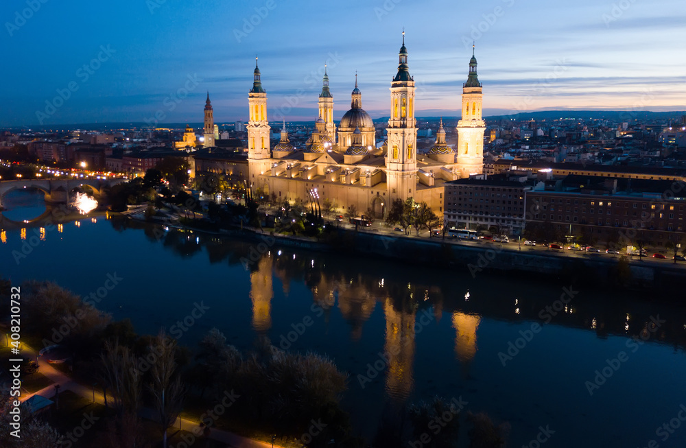 Night aerial view of Zaragoza with Cathedral-Basilica of Our Lady of Pillar on bank of Ebro river, Spain