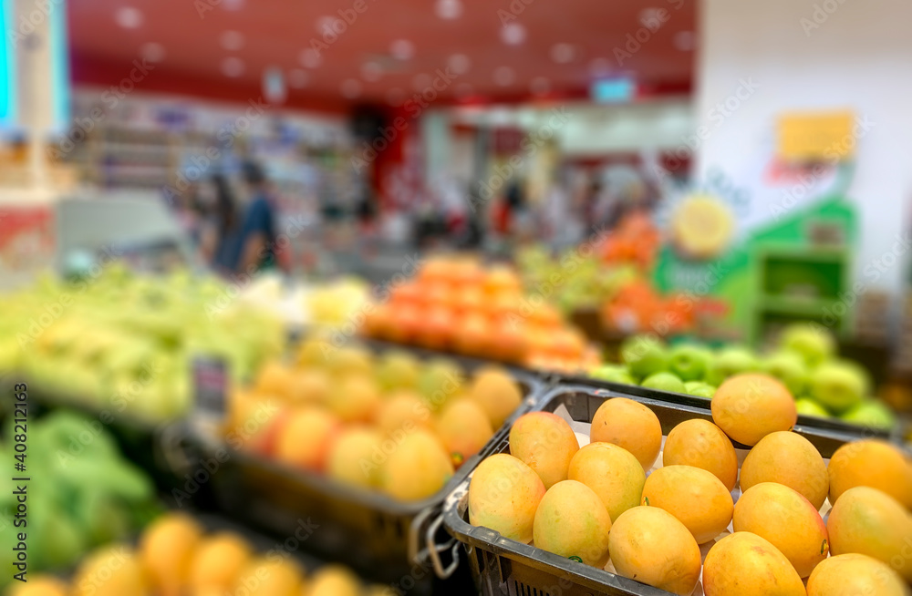 Abstract blur in supermarket with oranges and variety of fruits.