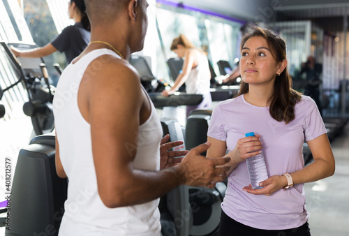 Man and woman talking during workout break in the gym