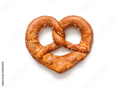 Fototapeta German pretzel sprinkled with sesame seeds, isolated on white