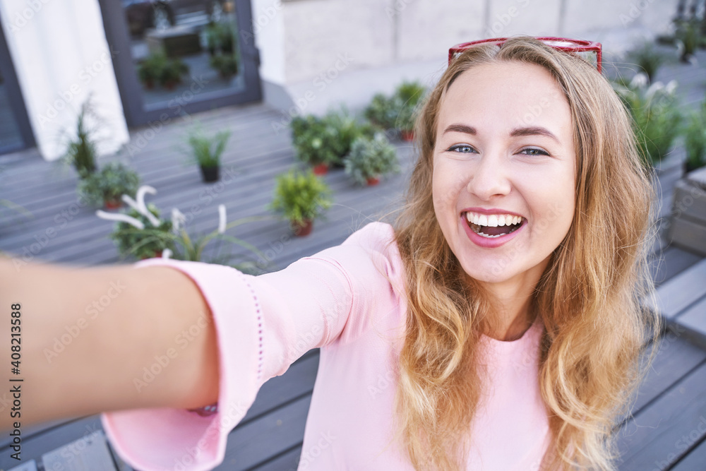 Young woman doing self portrait outside. City vacation portrait. Blogger selfie video. travel local. Alone tourist. Happy emotion. Smiling female person. Lifestyle action. Posing Young woman doing self portrait outside. City vacation portrait. Blogger selfie video. travel local. Alone tourist. Happy emotion. Smiling female person. Lifestyle action. Posing