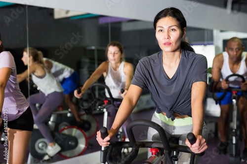 Sporty woman doing cardio exercises training on stationary bike