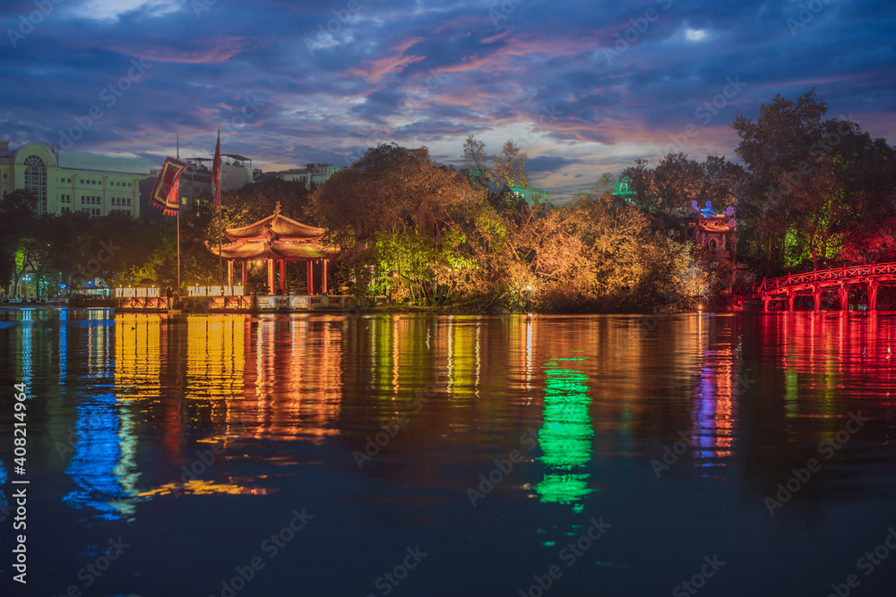 Hanoi Red Bridge at night. The wooden red-painted bridge over the Hoan Kiem Lake connects the shore and the Jade Island on which Ngoc Son Temple stands