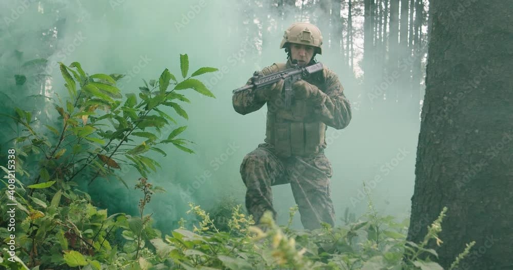 Soldiers running millitary action in dense forest with smoke in backgorund, army conducting action in forest