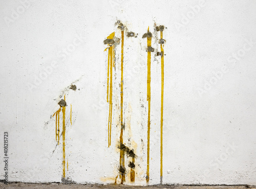 Multiple yellow epoxy injections to repair or stop water leaks. Injection waterproofing method on negative side in poured concrete structure such as parkade, foundation or basement. photo