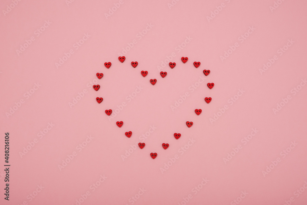 Valentine's Day heart shape made of small red hearts on pink background