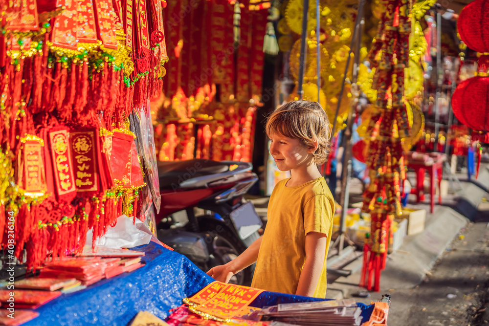 Caucasian tourist boy in Tet holidays. Vietnam Chinese Lunar New Year in springtime. TEXT TRANSLATION from Vietnamese: Congratulations on the Vietnamese, Chinese New Years and wishes of all the best