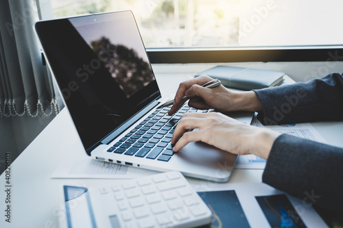 Business woman hands using laptop analysis the graph for Setting challenging business goals and ready to achieve the target