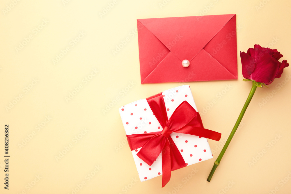 Valentine's Day: Red envelope with a letter, gift and red roses on beige background