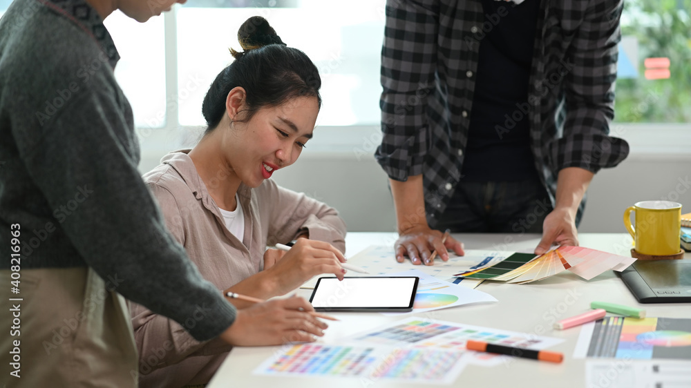 Group of young Asian designer using digital tablet and selecting color for the new product at modern office. Group of young Asian designer using digital tablet and selecting color for the new product at modern office.