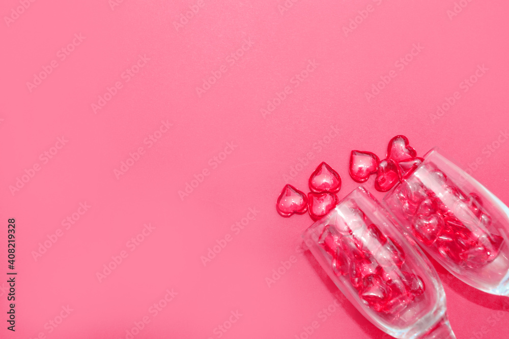two glasses with hearts on a red background. the view from the top. red hearts spilled out of the glasses. isolated on a pink background. copy space two glasses with hearts on a red background. the view from the top. red hearts spilled out of the glasses. isolated on a pink background. copy space