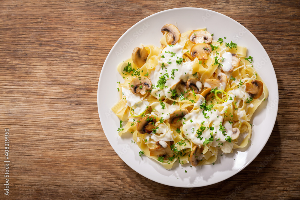 plate of pasta with cream sauce and mushrooms, top view plate of pasta with cream sauce and mushrooms, top view