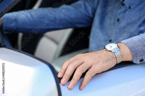 Handsome man with stylish wristwatch driving car © Pixel-Shot