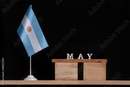 Wooden calendar of May with Argentine flag on black background. Dates of Argentina in May