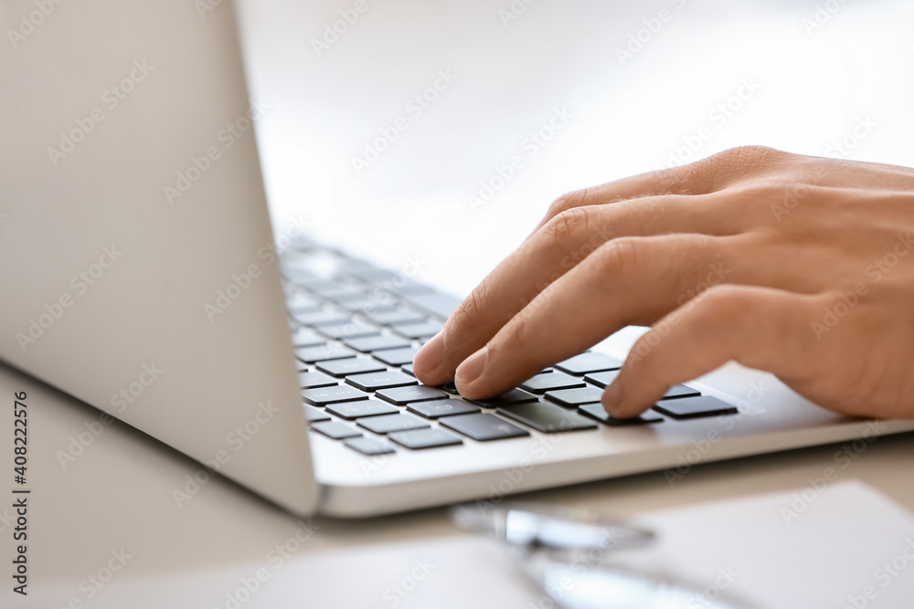 Young man working on laptop at table, closeup Young man working on laptop at table, closeup