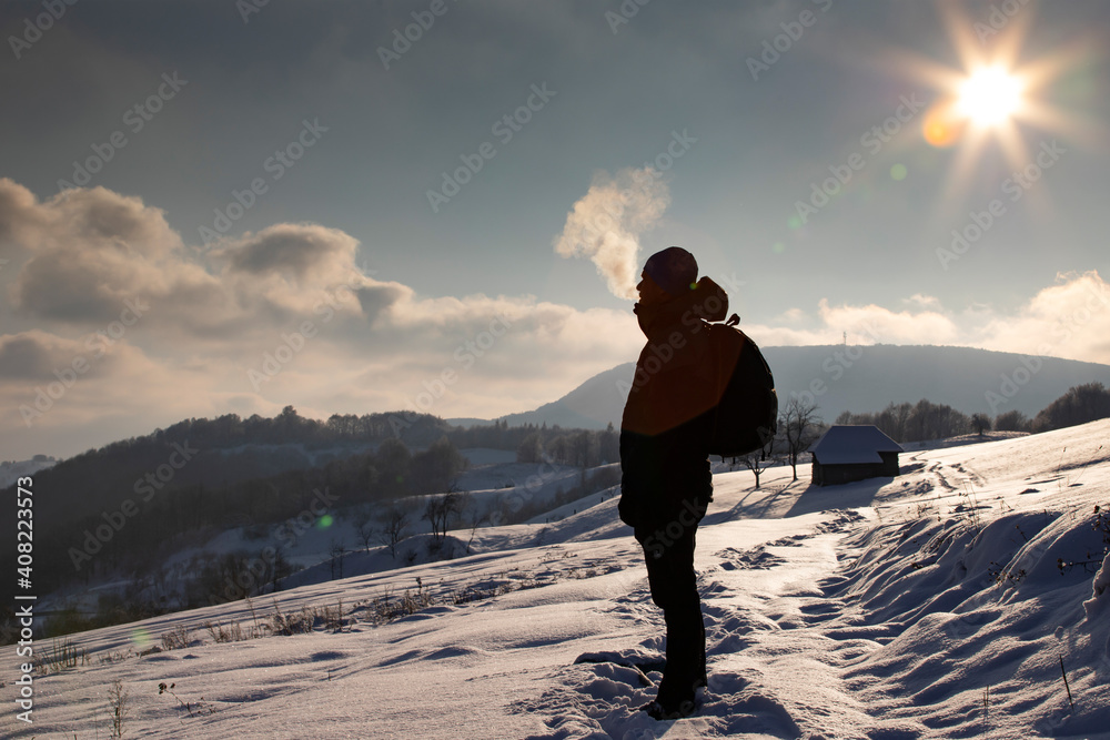 Silhouette Of A Man With Backpack And Hiking On A Mountain