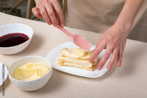 Process of making cake with vanilla cream and jam. Pastry chef preparing pie