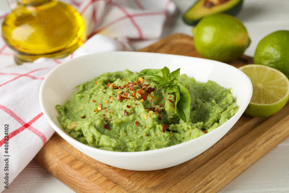 Bowl with guacamole, spices and basil, close up