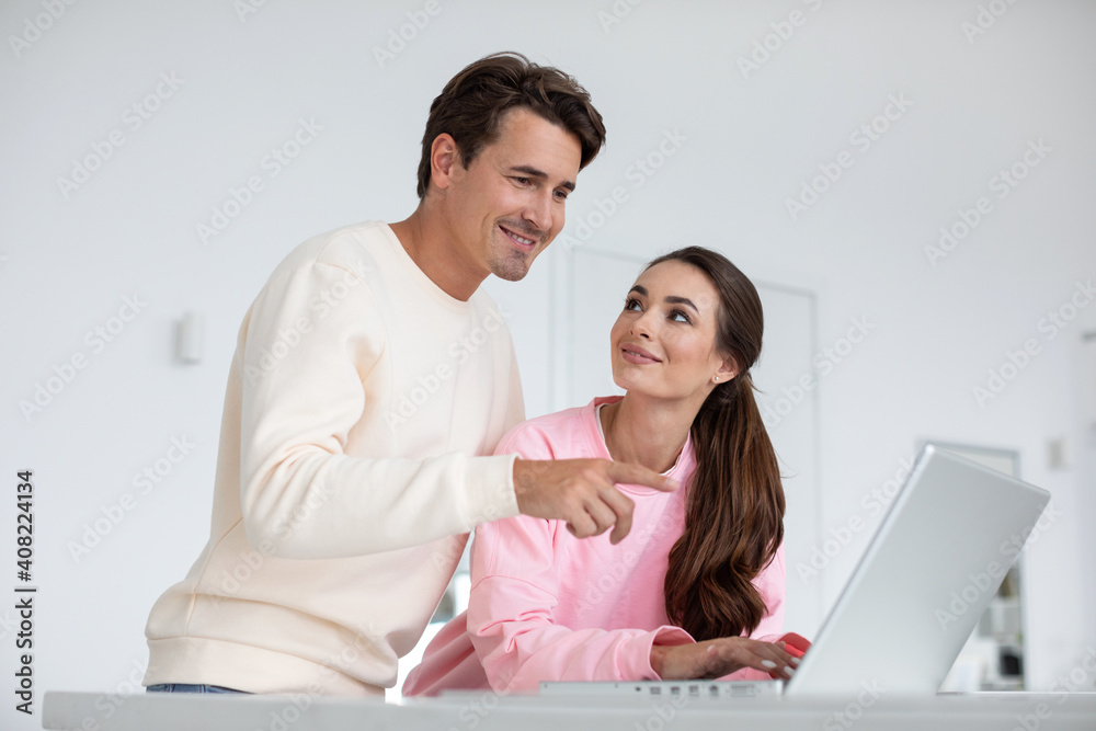 Beautiful couple in love using laptop choose online shopping at home.