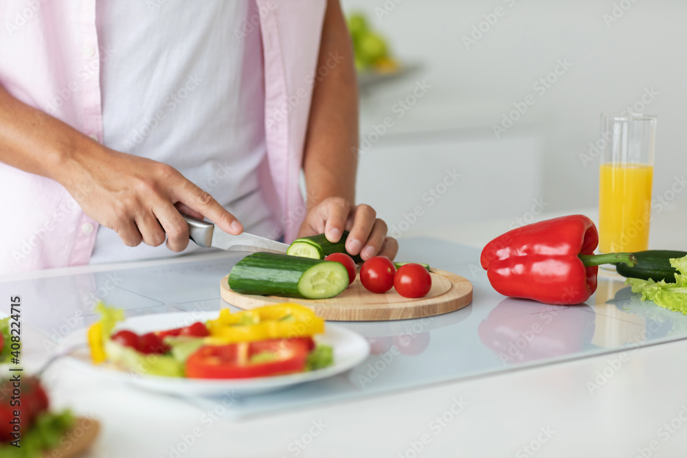 Close-up of a man preparing vegetable salad in the kitchen at home. Close-up of a man preparing vegetable salad in the kitchen at home.