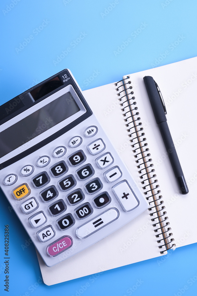 Calculator keypad on a blue background.Notebook, pen, glasses, desktop. Finances Top view. Copy space Calculator keypad on a blue background.Notebook, pen, glasses, desktop. Finances Top view. Copy space