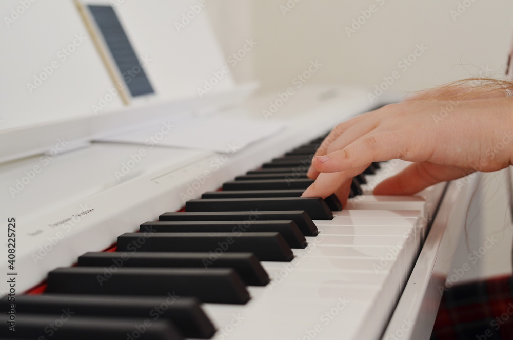 Childrens fingers press the piano keys.