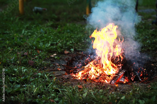 Burning red hot sparks fly from big fire. Burning coals, flaming particles flying off against black background.