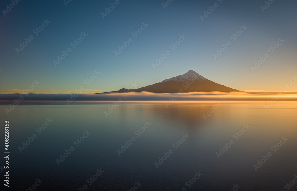Volcano and lake: the volcano Osorno reflecting in the lake Lago Llanquihue at sunrise