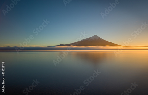Volcano and lake: the volcano Osorno reflecting in the lake Lago Llanquihue at sunrise