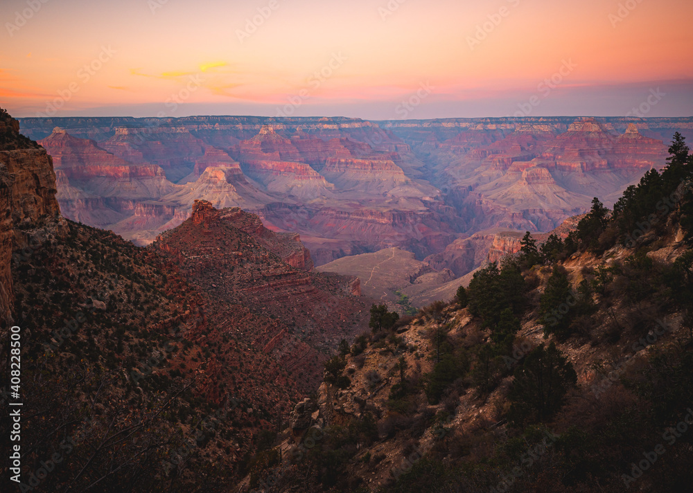 Vivid orange and pink sunset looking over the Grand Canyon at the top of the Bright Angel Trail. 