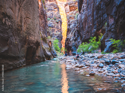 The sun's orange glow reflects off the Virgin River in The Narrows. Zion National Park