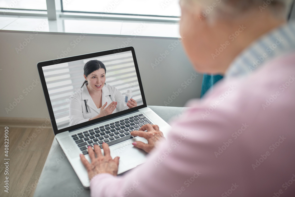 Senior woman having an appointment with online doctor