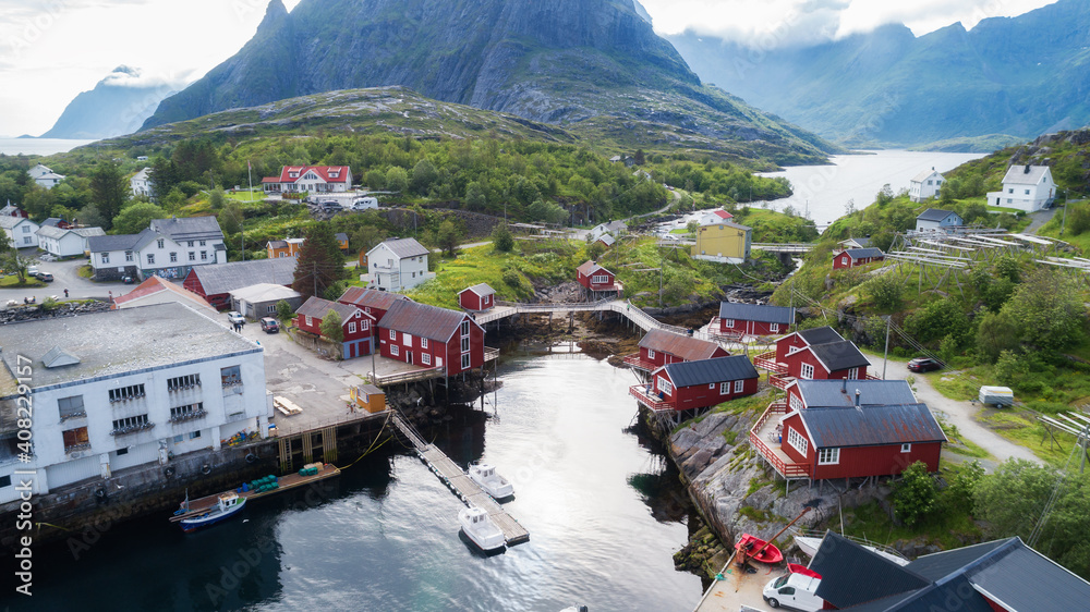 View of red fishing cabins at summer. Panorama with mountains in the background.Lofoten, Norway