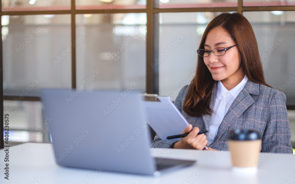 Closeup image of a beautiful young asian business woman using laptop computer while working in office Closeup image of a beautiful young asian business woman using laptop computer while working in office