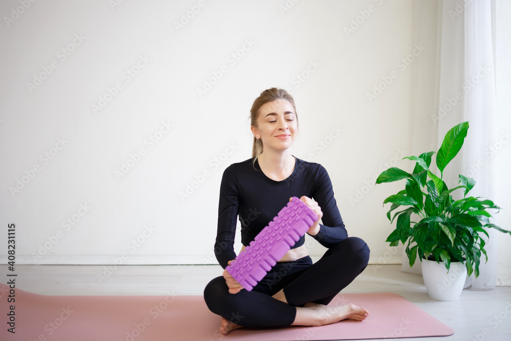 young beautiful woman hold in her hands massage roller