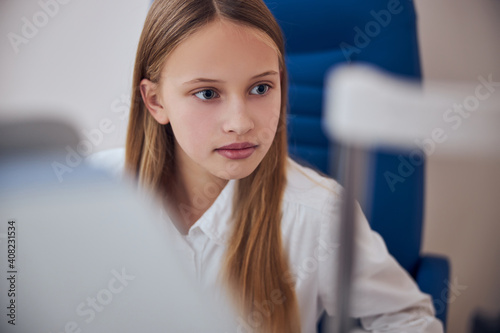 Free Download Seriously blonde girl spending time in office of pediactric ophthalmologist - GFXLoad