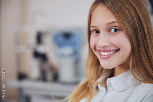 Pretty young lady in white shirt looking and posing at the photo camera in room indoors