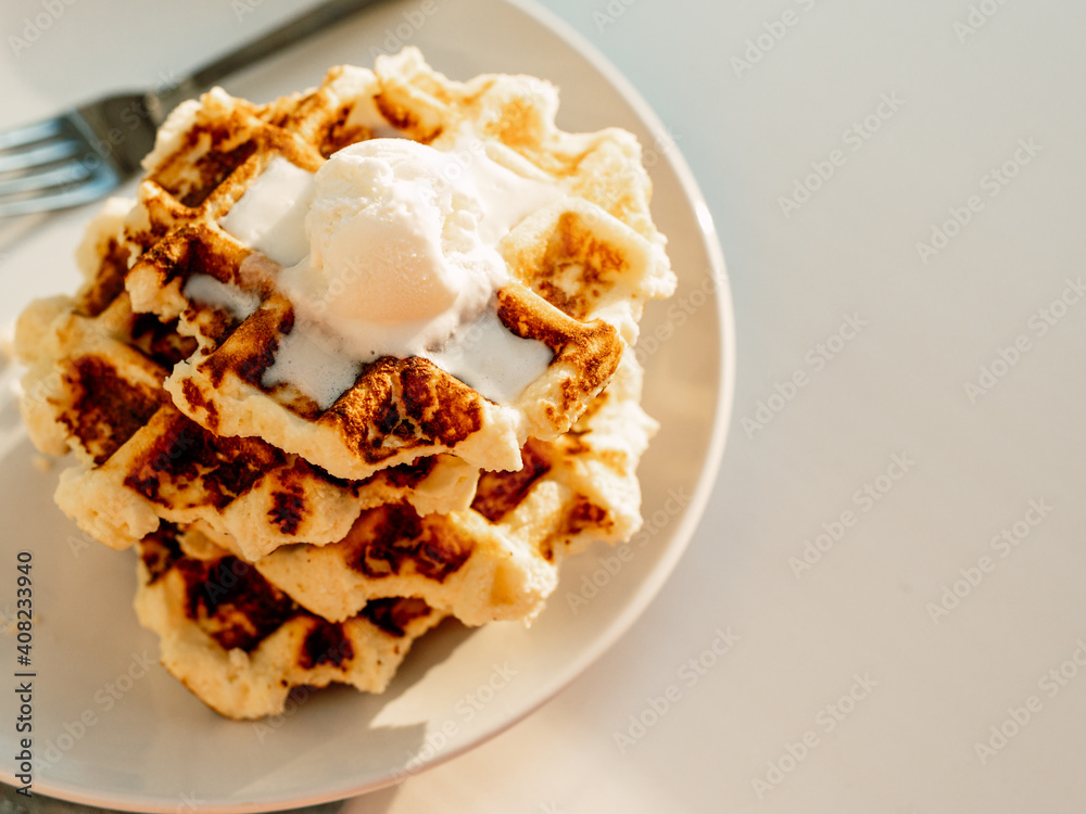 Ricotta cheese chaffles for keto diet. Stack of ricotta and lemon belgian waffles decorated with ice cream scoop.Copy space for text or design. Natural sunset or sunrise daylight. Top view or flat lay Ricotta cheese chaffles for keto diet. Stack of ricotta and lemon belgian waffles decorated with ice cream scoop.Copy space for text or design. Natural sunset or sunrise daylight. Top view or flat lay