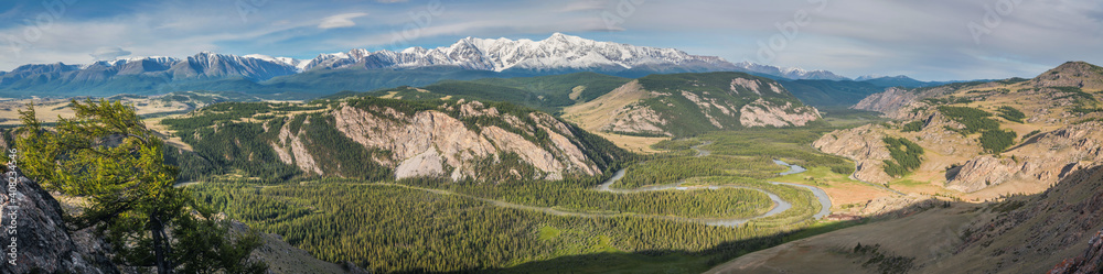 Panoramic view of the Altai mountains. Valley with a river and snow-capped peaks.
