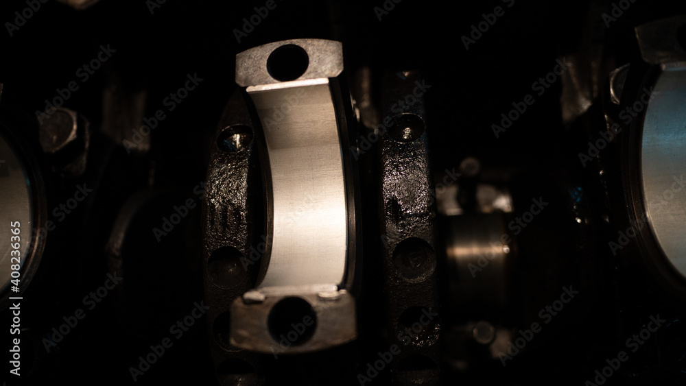 Fototapeta premium The car parts lie on the internal combustion engine. Close-up of connecting rods on the crankshaft. Car spare parts. Car engine motor repair