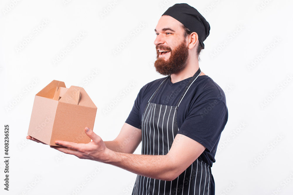 Photo of happy chef man giving a food box to delivery. Photo of happy chef man giving a food box to delivery.