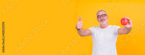 senior man holding an apple and making ok gesture, diet and health concept