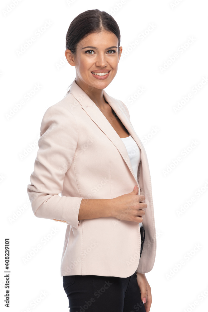 side view of happy attractive businesswoman smiling and fixing jacket