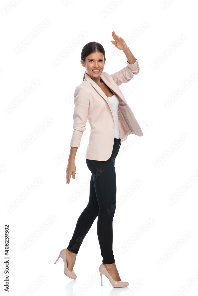 Obraz premium happy young businesswoman in pink jacket smiling and military saluting